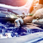 Car mechanic repair engine at service station. Car repair.